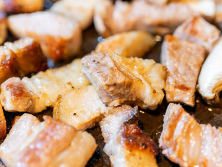 Pan-fried cooked black pork meal in Korea restaurant, fresh delicious korean food cuisine on iron plate with lettuce, close up, copy space, lifestyle