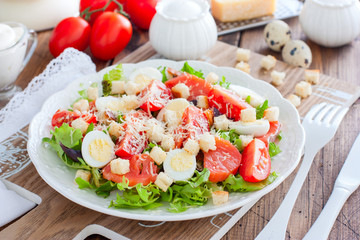 Caesar salad with red fish on the wooden table, horizontal