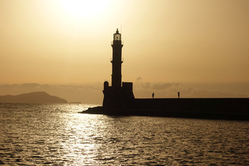 Photo of iconic Venetian lighthouse in old port of Chania at sunset with golden colours, Crete island, Greece