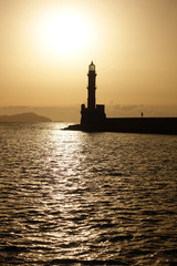 Photo of iconic Venetian lighthouse in old port of Chania at sunset with golden colours, Crete island, Greece