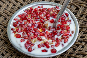 Muesli and yogurt with banana, apple, pomegranate seeds and oat cereals, healthy food concept, close up