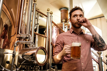 Man tasting fresh beer in a brewery