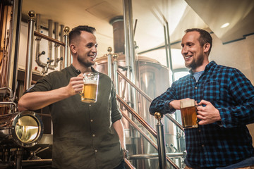 Two men tasting fresh beer in a brewery