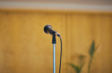 Microphone in the foreground with neutral background. Picture taken in a modern church, Event...