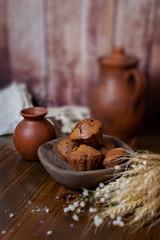 homemade chocolate cupcakes without cream on the background of clay jugs