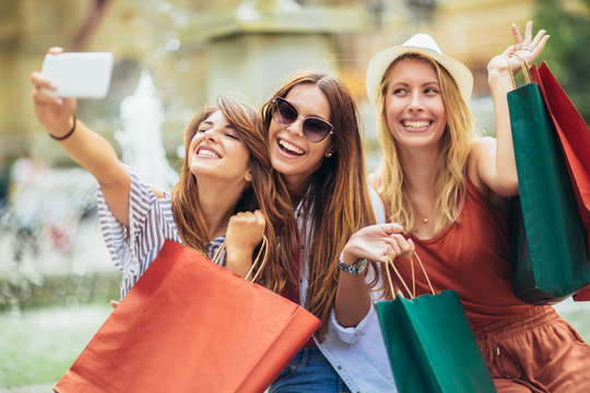 Three women shopping together and make selfie photo