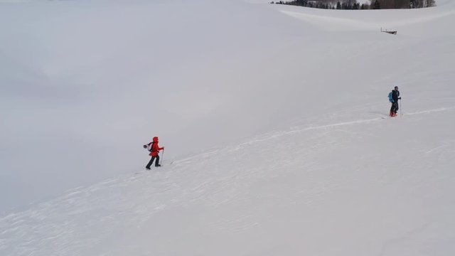 Ski touring and splitboarding concept. Group tourist people walking on ski in snowy mountain while winter travel aerial view. Winter sport hike and travel