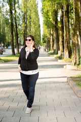 Fototapeta premium Lady Walks on the Streets of Munich while Working on the Go