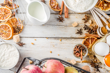 Autumn baking sale concept. Cooking seasonal fall baking background with ingredients, spices, apples, supplies, white wooden table top view copy space
