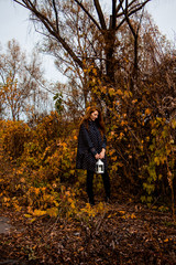 Fototapeta premium young redhead woman with white lamp in the hand in autumn park