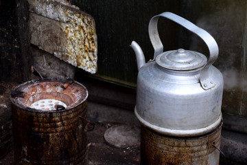 Boiling tea pot on simple stove outdoors in a street food kitchen with the other stove being empty