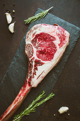 Top view of raw dry-aged marble beef steak Tomahawk with spices. Flat lay, cooking concept.