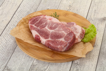 Raw pork steak over wooden board