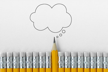 Pencil tip standing out from croud of pencil rubber erasers with empty thought bubble