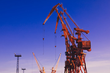 Mobile harbor cranes over blue sky. Transport and technology concept