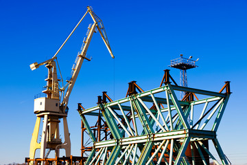 Mobile harbor cranes over blue sky. Transport and technology concept
