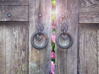 antique door with door handles in the form of rings. open door and heaven light 