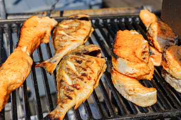 close up of tasty roasted salmon and perch on grill outdoors. Street food.