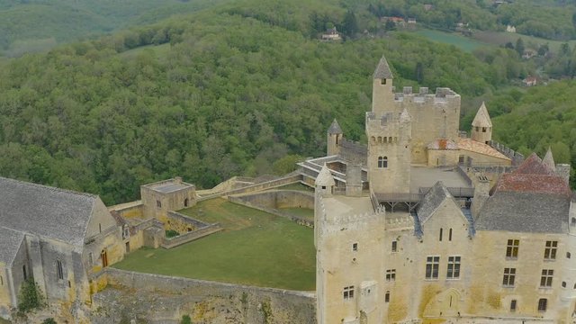 Side view of a facade, gardens and details of Castle of Beynac, at village of Beynac et Cazenac located in Aquitanie, Southern France