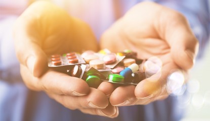 Pills in human hands, close-up view
