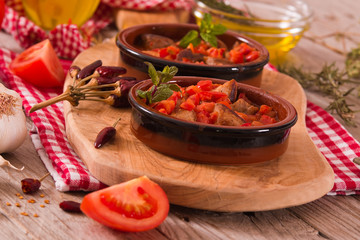 Marinated pork loin in tomato sauce.