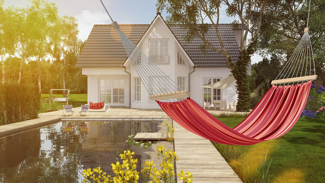 Hammock in front of house in the garden with pond