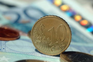 Ten Eurocent coin among other money closeup. Shallow depth of field