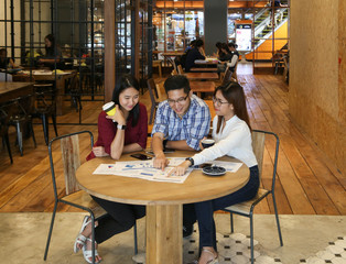 Group of casual Business meeting to discuss ideas and laptop on table in coffee shop.