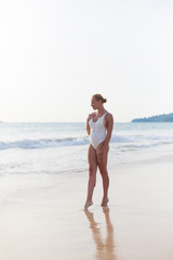 Fototapeta na wymiar Model on the beach in white dress 