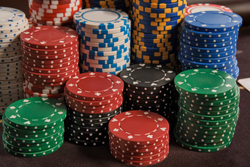 Close-up shot of a poker chips stacks standing on a table in casino.