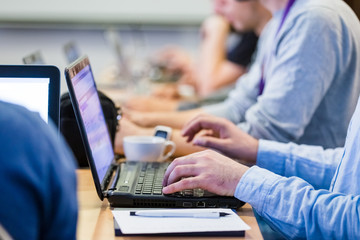 Close up of hands on laptops on a meeting or business conference.