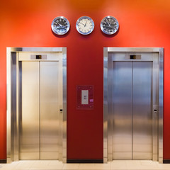 Modern steel elevator cabins with closed door in a business lobby.