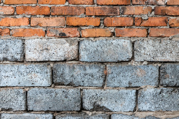 Masonry of red clay bricks lined over gray foam concrete blocks.