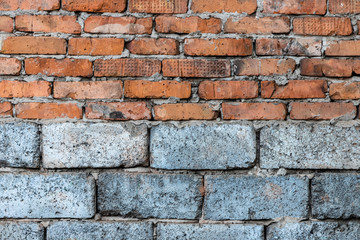 Masonry of red clay bricks lined over gray foam concrete blocks.