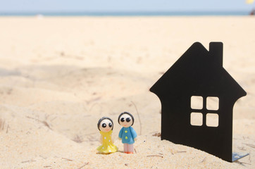 Naklejka premium miniature couple and miniature house on the beautiful tropical beach.