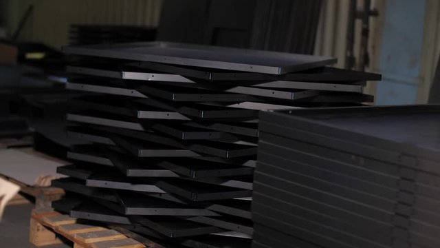  Close up many metal sheets lie on each other. Finished products industrial plant. Cut metal sheets are on the processing table. Manufacturing of metal parts for industry. 