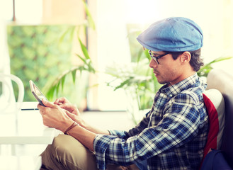 leisure, technology, communication and people concept - creative man with tablet pc computer sitting at cafe table