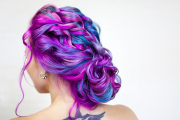 Elegant hairstyle of curls on long colored hair, styling. Bright color coloring, concept.