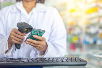 Pharmacist is scanning barcode of medicine in a pharmacy drugstore. Health care and medical...