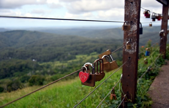 Maleny, Australia - Apr 25, 2019. Couples showing their everlasting love (Love you forever) by attaching a coloured padlock to the Gerrards lookout iron fence of the  as a token of love.