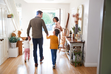 Rear View Of Family Leaving Home On Trip Out With Excited Children