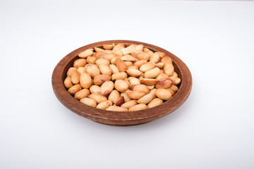 Peanuts in wooden plate, roasted peanuts on the white background