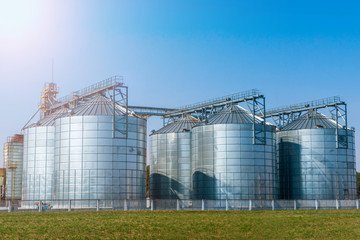 Obraz premium silver silos on agro manufacturing plant for processing drying cleaning and storage of agricultural products, flour, cereals and grain