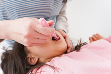 子供の歯を磨くお母さん