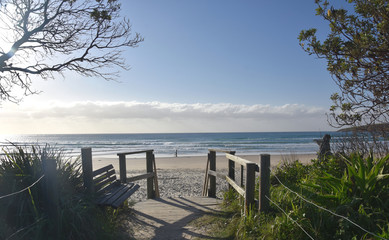 Old wooden walkway path entrance to the beach. Sandy ocean beach entrance. Sea beach wooden walkway path entrance. Sandy ocean beach entrance.