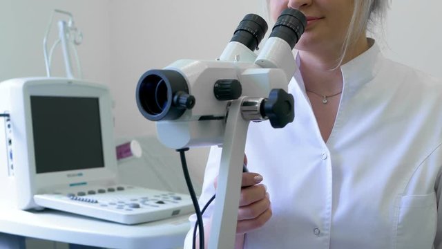 A professional gynecologist woman examines a patient with a colposcope in a gynecological clinic. Examination by a doctor in a medical clinic. The concept of female health. Specialized equipment