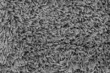 Black natural fleece carpet texture background. Dark wool fabric texture. fragment gray shaggy mat