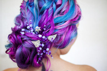 Wedding hairstyle of curls for a modern and unusual bride. Portrait of a young stylish woman with bright colored hair.