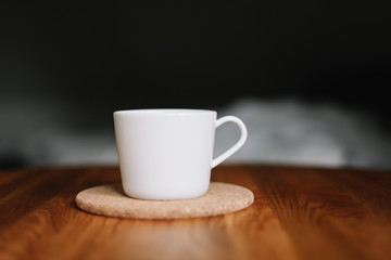 A white cup on wooden table. Morning coffee 