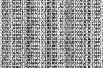 White and black knitted fabric background texture. gray fabric with a pattern. Fragment grey wool carpet, bright wicker dark rug